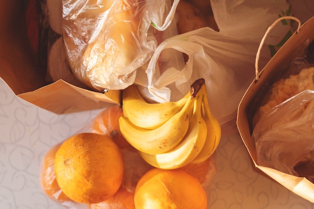 Paper and plastic bags packages with food on the table