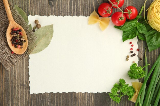 Paper for recipes vegetables and spices on wooden table