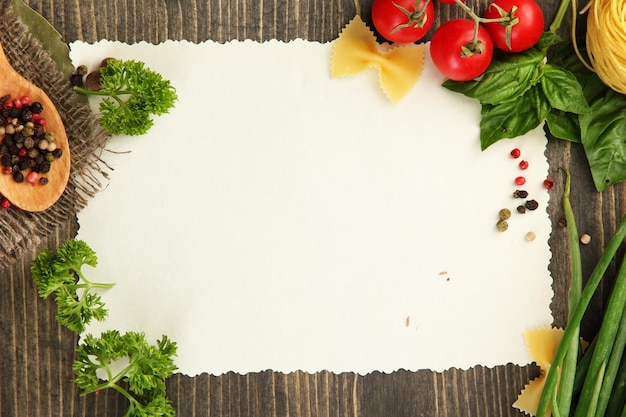 paper for recipes vegetables and spices on wooden table