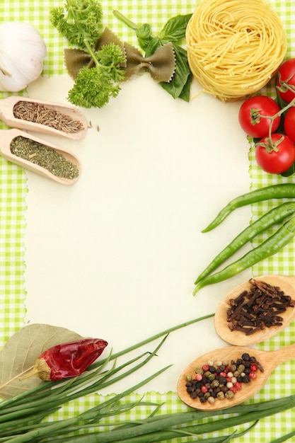 Paper for recipesvegetables and spices on green background