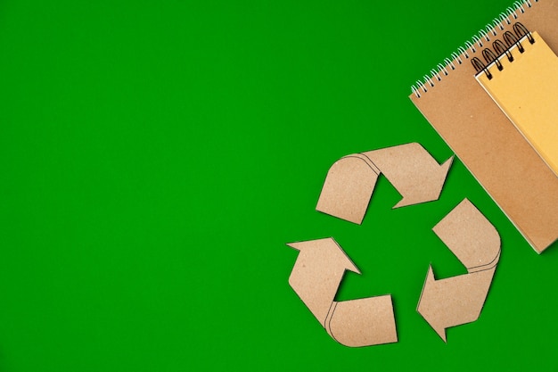 Paper recycling concept on green background top view, copy space