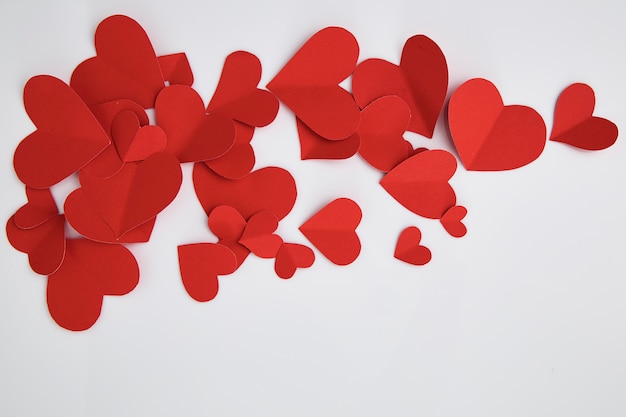 Paper red hearts on white background