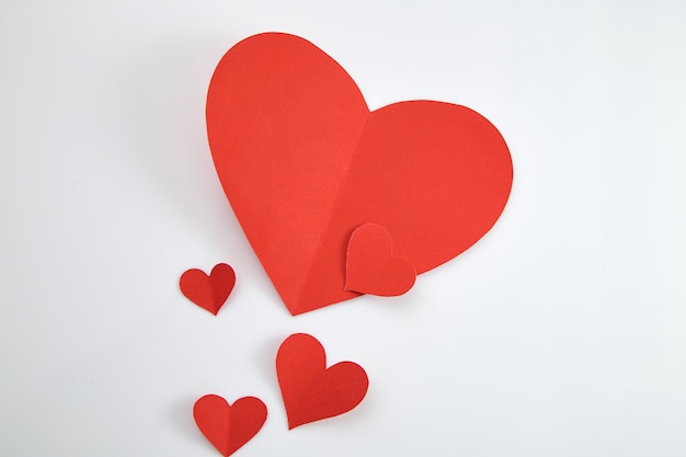 Paper red hearts on white background