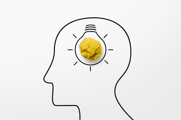 Paper scrap ball yellow colour and light bulb in head human symbol. Creative idea concept.