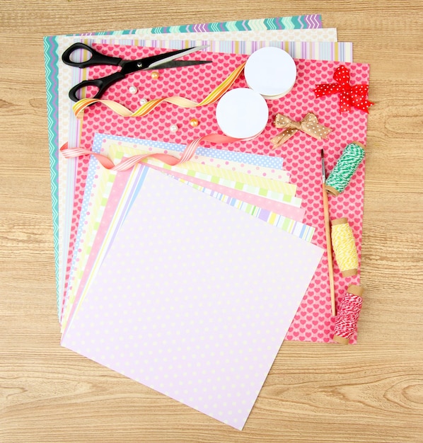 Foto carta per scrapbooking e strumenti sulla tavola di legno