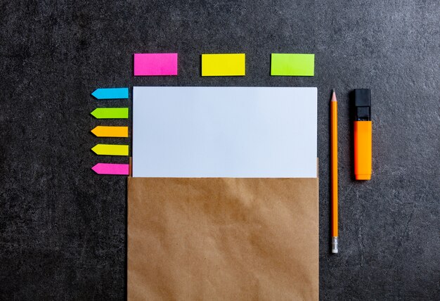 Paper sheet, pencil and notes around on gray table