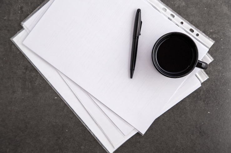 Photo paper sheet with copy space and black pen with cup coffee