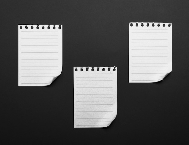  paper sheets torn from a notepad with a folded bottom corner 