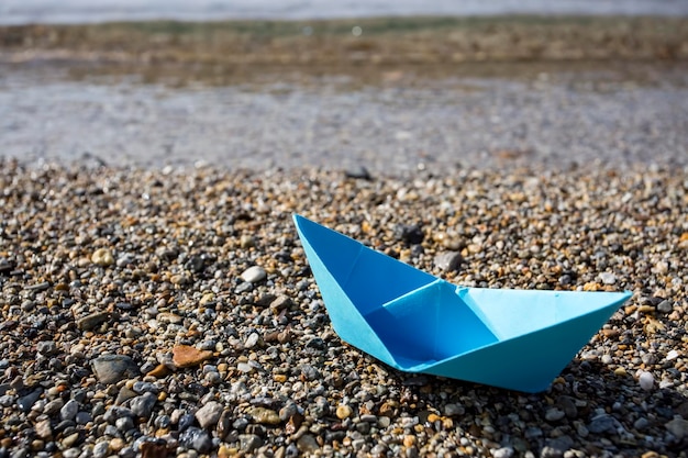 Бумажный корабль и море. Концепция путешествия.