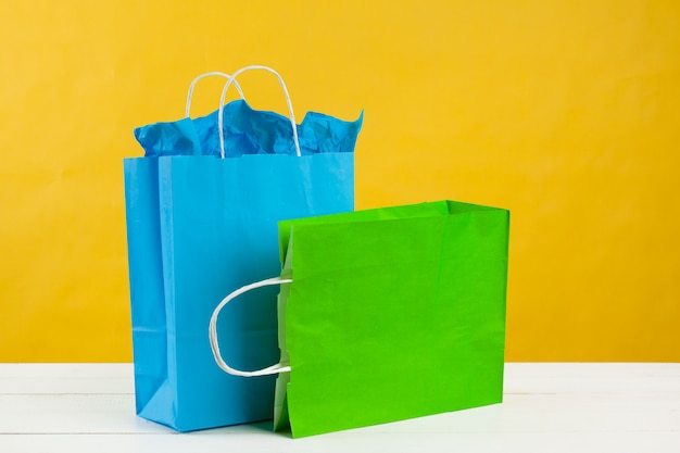 Paper shopping bags on bright yellow background