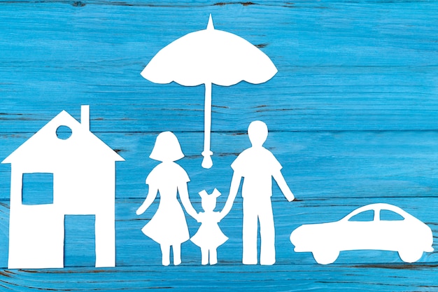 Paper silhouette of family under umbrella
