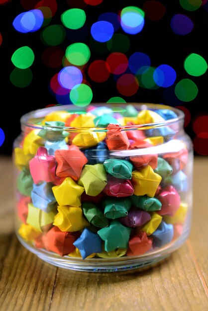 Paper stars with dreams on table on dark background