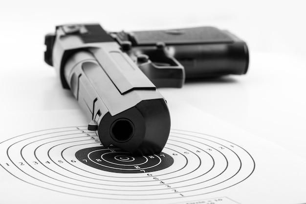 Paper target and pistol on white