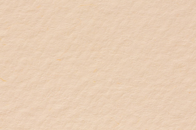 Paper texture light rough textured spotted blank copy space background in beige yellow brown High resolution photo