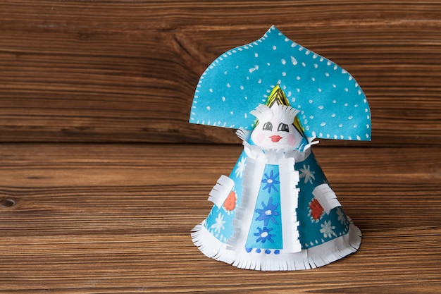 Paper toy Snow Maiden on a wooden 