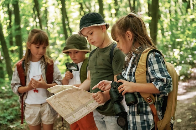 paper traditional map kids in forest at summer daytime together