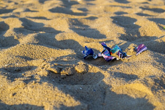 Photo paper trash sprinkled with sand on the sea beach