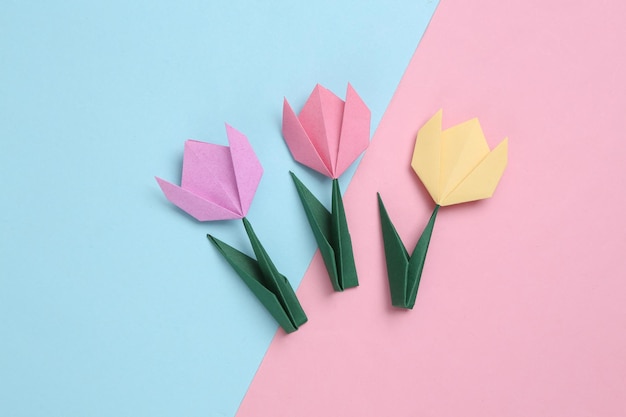 Paper tulips flower on pink blue pastel background 8 March women's day concept Handmade origami tulip Top view Minimalism