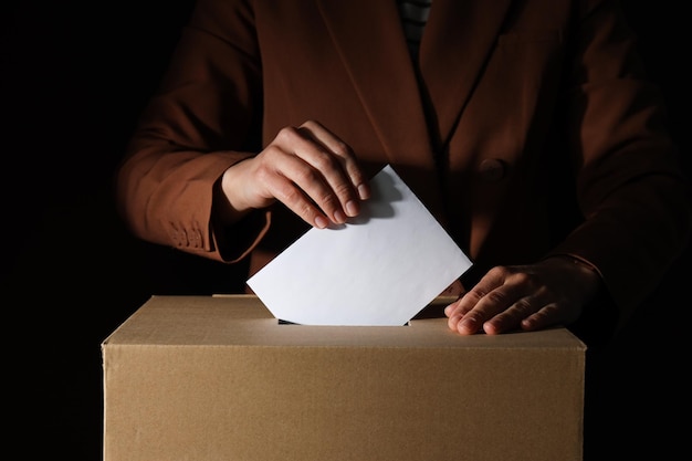 Paper voting box with form and men on black background close up