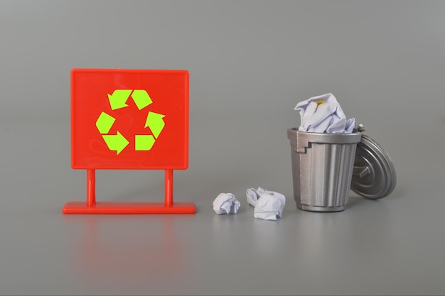 Paper waste loaded into a recycling bin with the appropriate recycle symbol