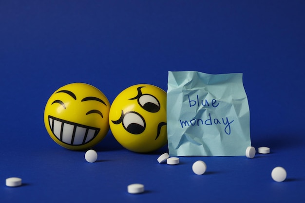 Paper with Blue Monday text pills and emoji on blue background