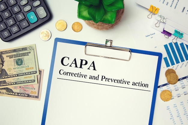 Paper with Corrective and Preventive action CAPA on the table, calculator and glasses