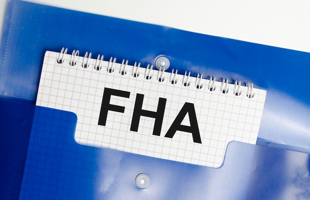 Paper with FHA loan on table with blue folder