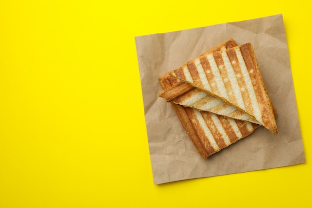 Фото Бумага с жареными бутербродами на желтом фоне