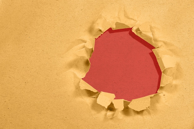 Paper with a hole torn in the middle with red background