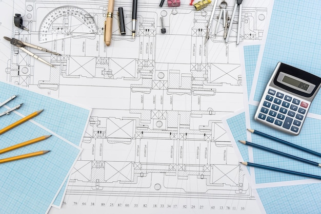 Paper with technical drawings and work tool on table