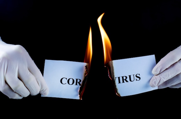 Paper with the text Coronavirus is burning on a black background. The concept of victory in the fight against the virus.