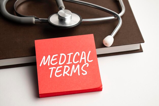 Paper with text medical terms on blue background with stethoscope and pills