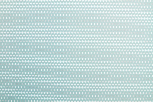 Paper with white plus signs on a light blue background