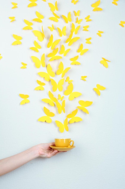 Paper yellow butterflies fly out of cup