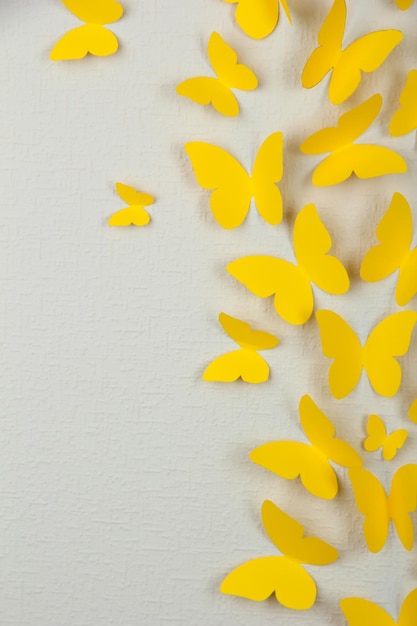 Paper yellow butterflies fly on wall in different directions