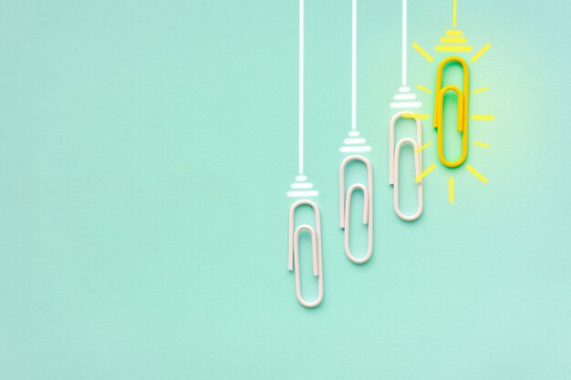 Idea graffetta concetto di successo grandi idee creative lampadina incandescente graffetta su sfondo blu chiaro