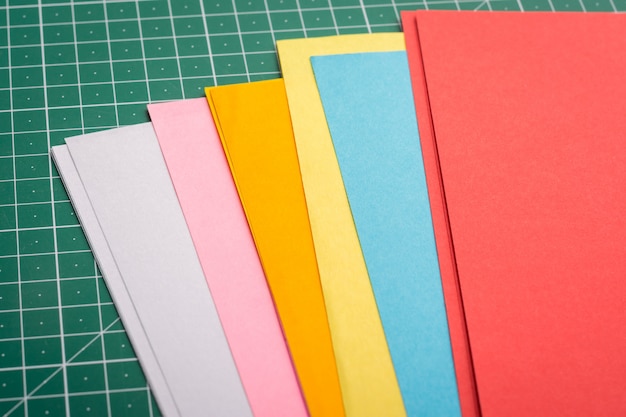 Photo papers for art of different size on green cutting mat