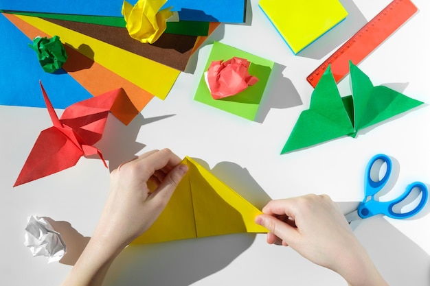 Papier ambachten schaar gekleurd papier op witte tafel origami kinderen werkplek kleuter