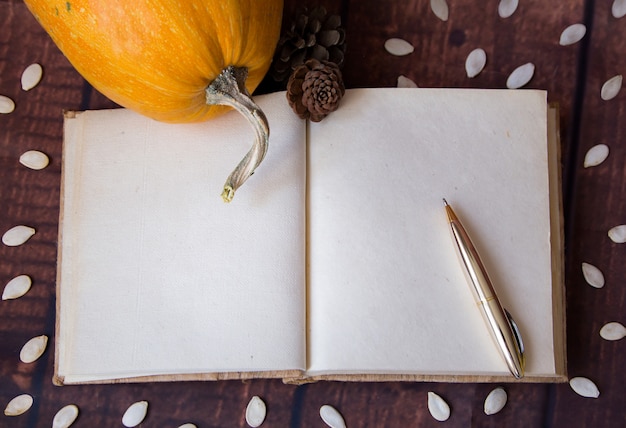 Papier en pompoen op houten bureau