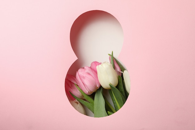 Papier gesneden Acht gemaakt van roze achtergrond en tulpen op witte achtergrond
