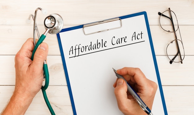 Papier met ACA Affordable Care Act op de kantoortafel en stethoscoop.