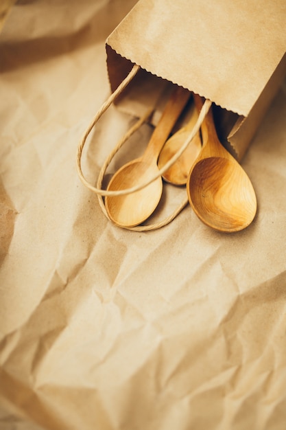 Papier pakketten met houten lepels op bruine achtergrond