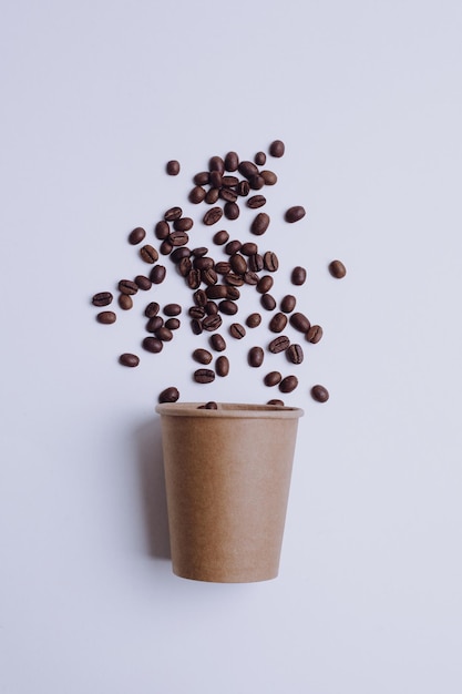 Papieren beker en koffiebonen geïsoleerd op een witte achtergrond Verpakkingsmodel voor koffieproduct