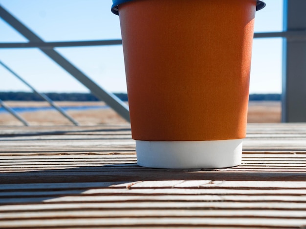 Papieren beker met deksel Koffiekopje op houten oppervlak Straatkoffie met prachtig uitzicht