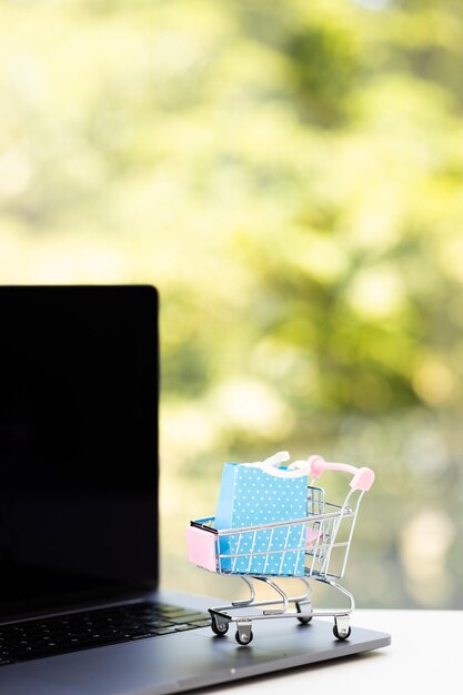 Papieren dozen in een trolley en boodschappentas op laptopcomputer