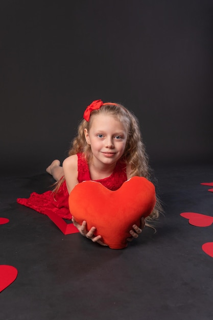 Papieren harten symbool valentijn op de vloer harten mooie bruiloft de inspiratie van de gelegenheid kopieer ruimte feestelijk zwart in rode jurk meisje op blote voeten