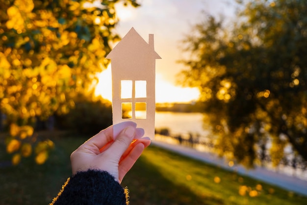 Papieren huis is tegen de avondrood. Concept van uw eigen huis, persoonlijke ruimte en hypotheek