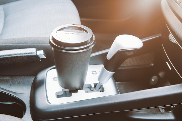 Papieren koffiekopje in een auto Papieren koffiekopje staat in de auto