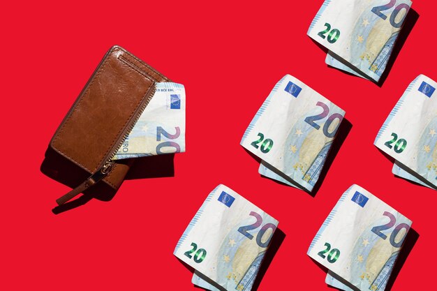 papieren rekeningen van 20 euro en een portemonnee op een rode achtergrond Cash concept