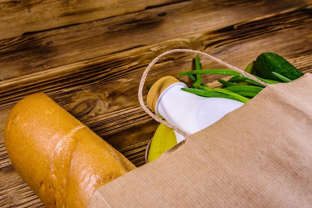 Papieren zak met ander voedsel uit de supermarkt op een houten tafel Supermarkt winkelconcept